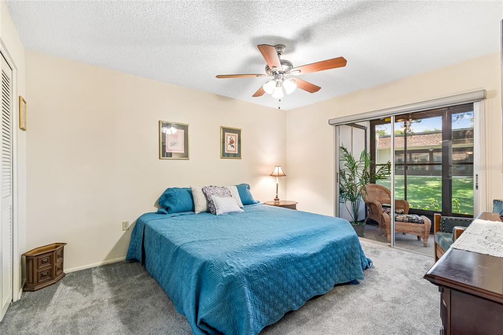 11340 Carriage Hill Drive, Unit 4 Port Richey, FL 34668 - Photo 15 of 36 a bedroom with a large bed and a chandelier