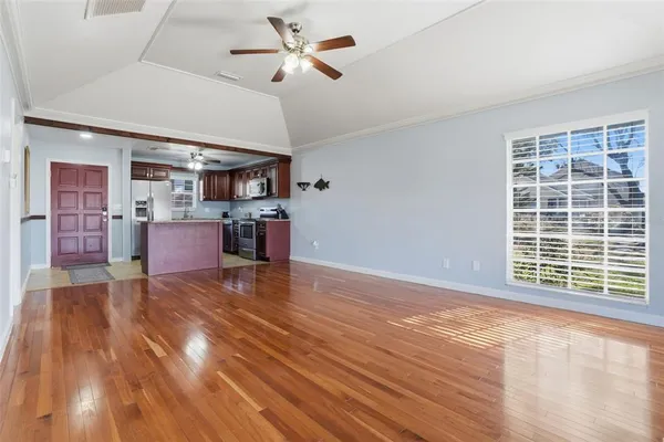 a view of empty room with kitchen and window