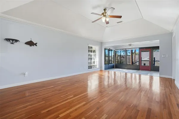 a view of an empty room with a window and wooden floor