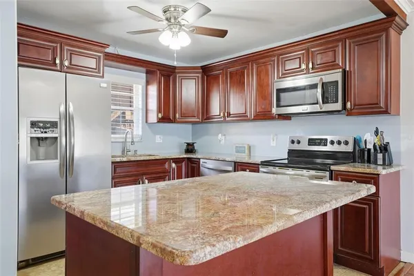 a kitchen with stainless steel appliances granite countertop a sink a stove and refrigerator
