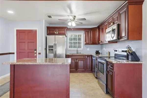 a kitchen with stainless steel appliances granite countertop a sink stove and refrigerator