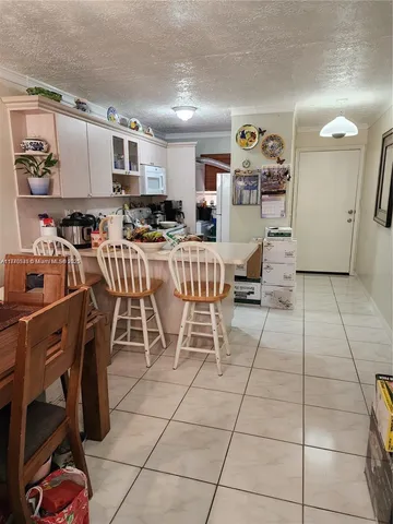 a living room with stainless steel appliances furniture and a kitchen view