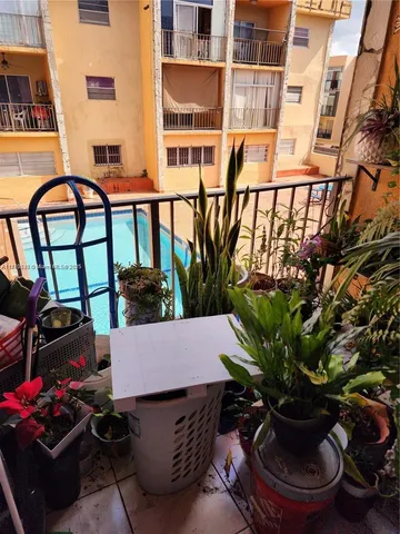 a view of a balcony with chairs and potted plants