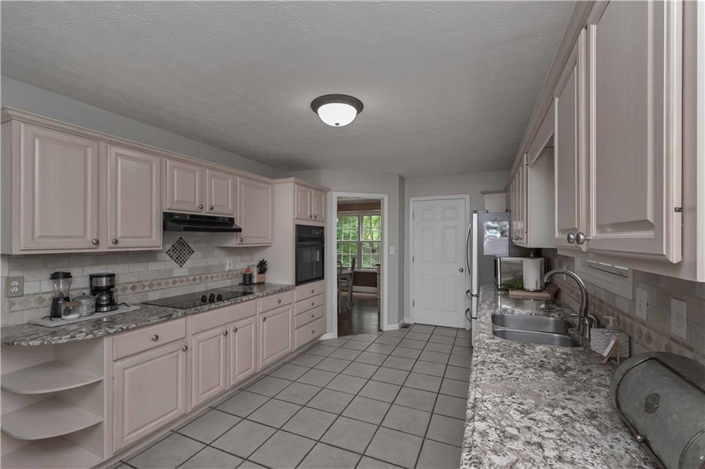 5885 West Chapel Hill Road Douglasville, GA 30135 - Photo 16 of 42 a kitchen with granite countertop a sink a stove and cabinets
