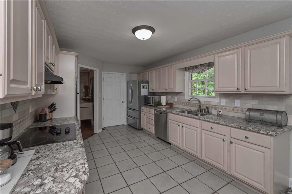5885 West Chapel Hill Road Douglasville, GA 30135 - Photo 17 of 42 a kitchen with stainless steel appliances granite countertop a sink and cabinets