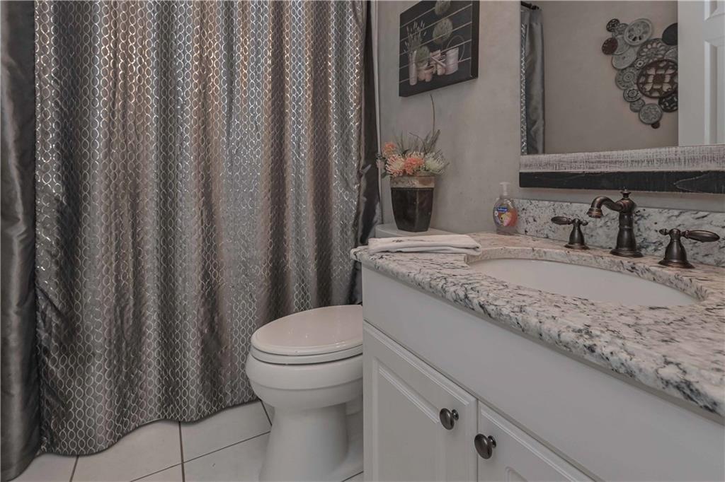 5885 West Chapel Hill Road Douglasville, GA 30135 - Photo 21 of 42 a bathroom with a granite countertop sink and a toilet