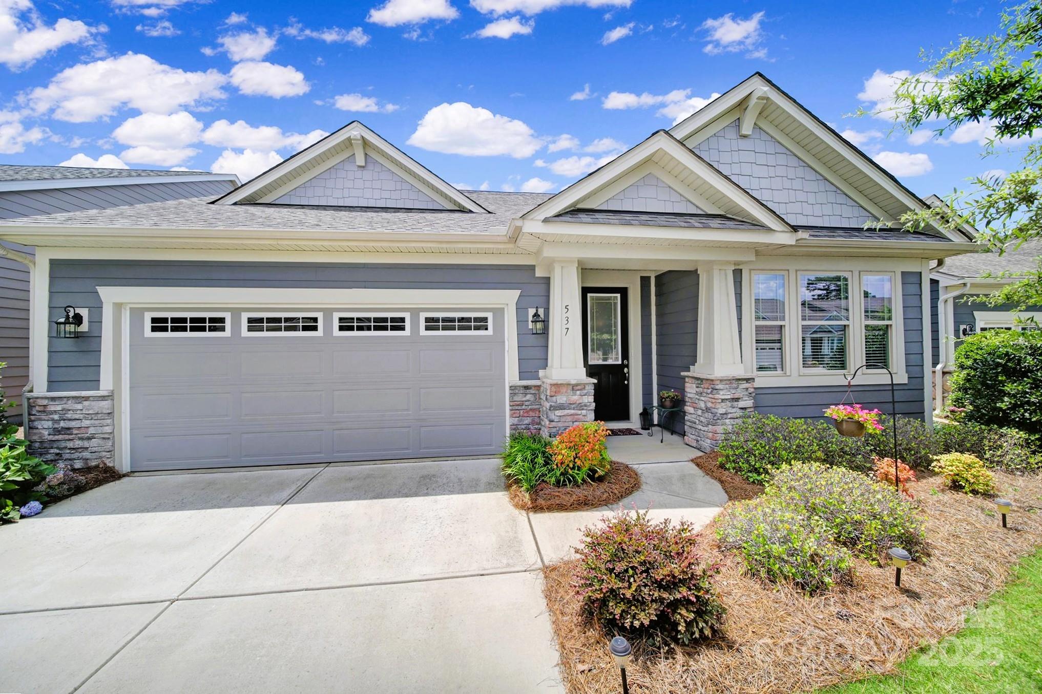a front view of a house with a yard and a garage