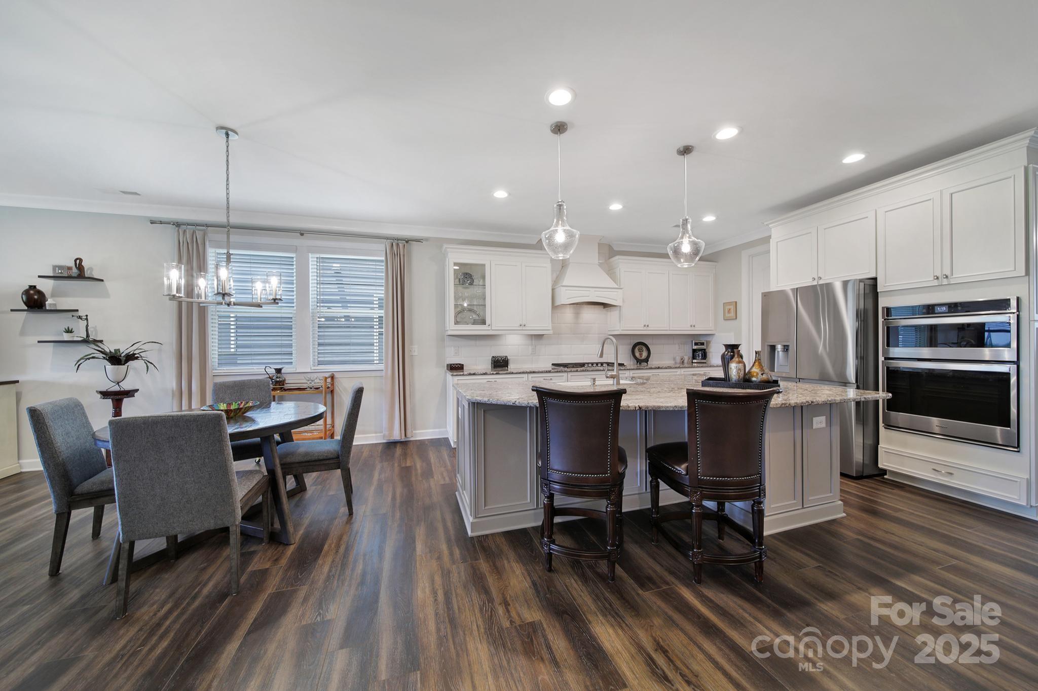 537 Lincoln Quarters Lane Fort Mill, SC 29708 - Photo 13 of 42 a kitchen with stainless steel appliances a dining table chairs refrigerator and sink