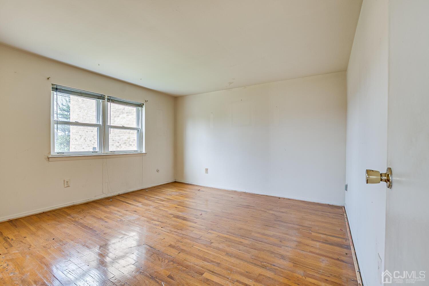 199 Evergreen Road, Unit 11A Edison, NJ 08837 - Photo 8 of 14 an empty room with wooden floor and windows