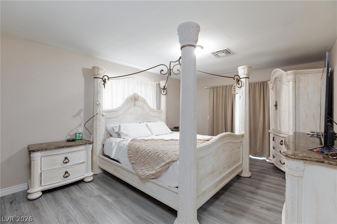 3640 North Walnut Road Las Vegas, NV 89115 - Photo 13 of 38 Relax in this tranquil bedroom, featuring light-toned flooring and window treatments for a serene escape.