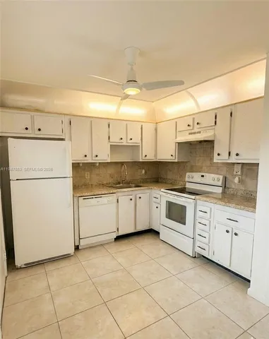 a kitchen with a white cabinets and white appliances
