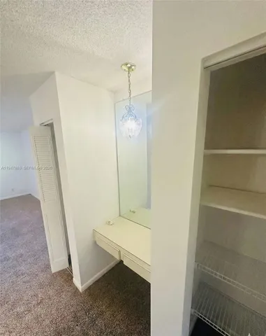 a bathroom with a granite countertop bathtub shower sink mirror and toilet