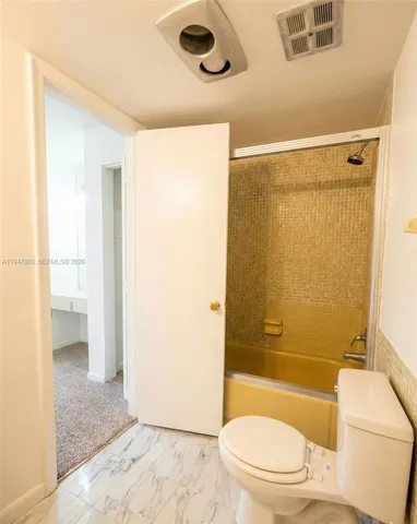 a spacious bathroom with a granite countertop sink mirror vanity and toilet