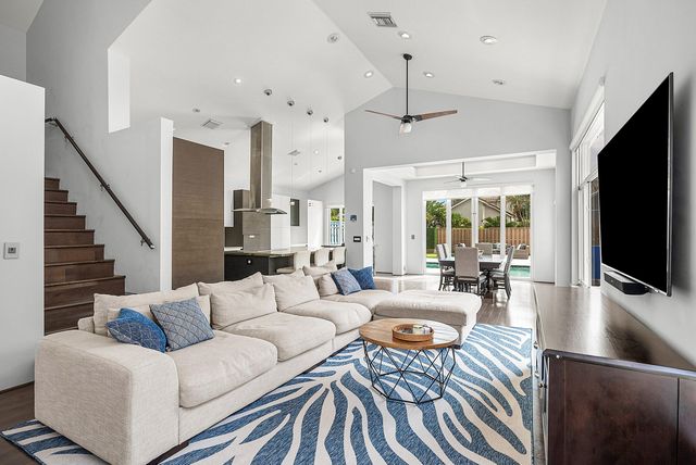 a living room with furniture flat screen tv and a large window