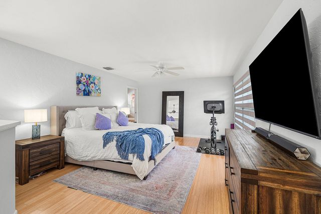 a spacious bedroom with a bed and a flat screen tv