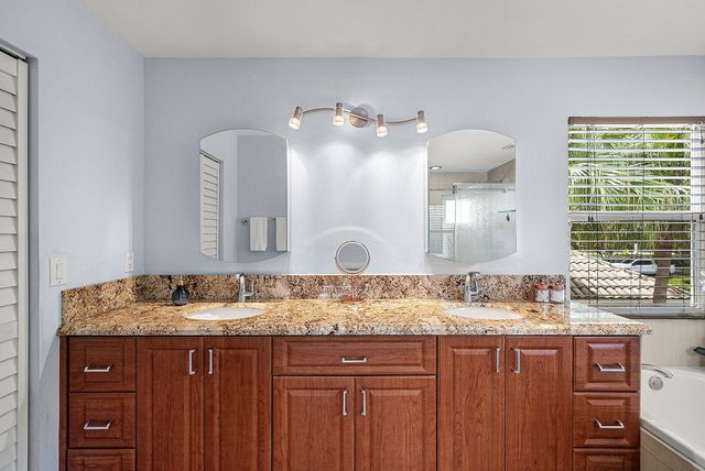 a bathroom with a granite countertop sink a large mirror and a window