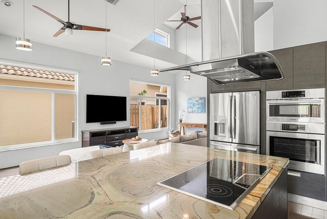 a living room with stainless steel appliances furniture and a flat screen tv