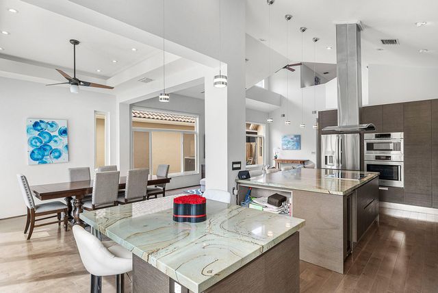 a kitchen with stainless steel appliances granite countertop a sink dining table and chairs