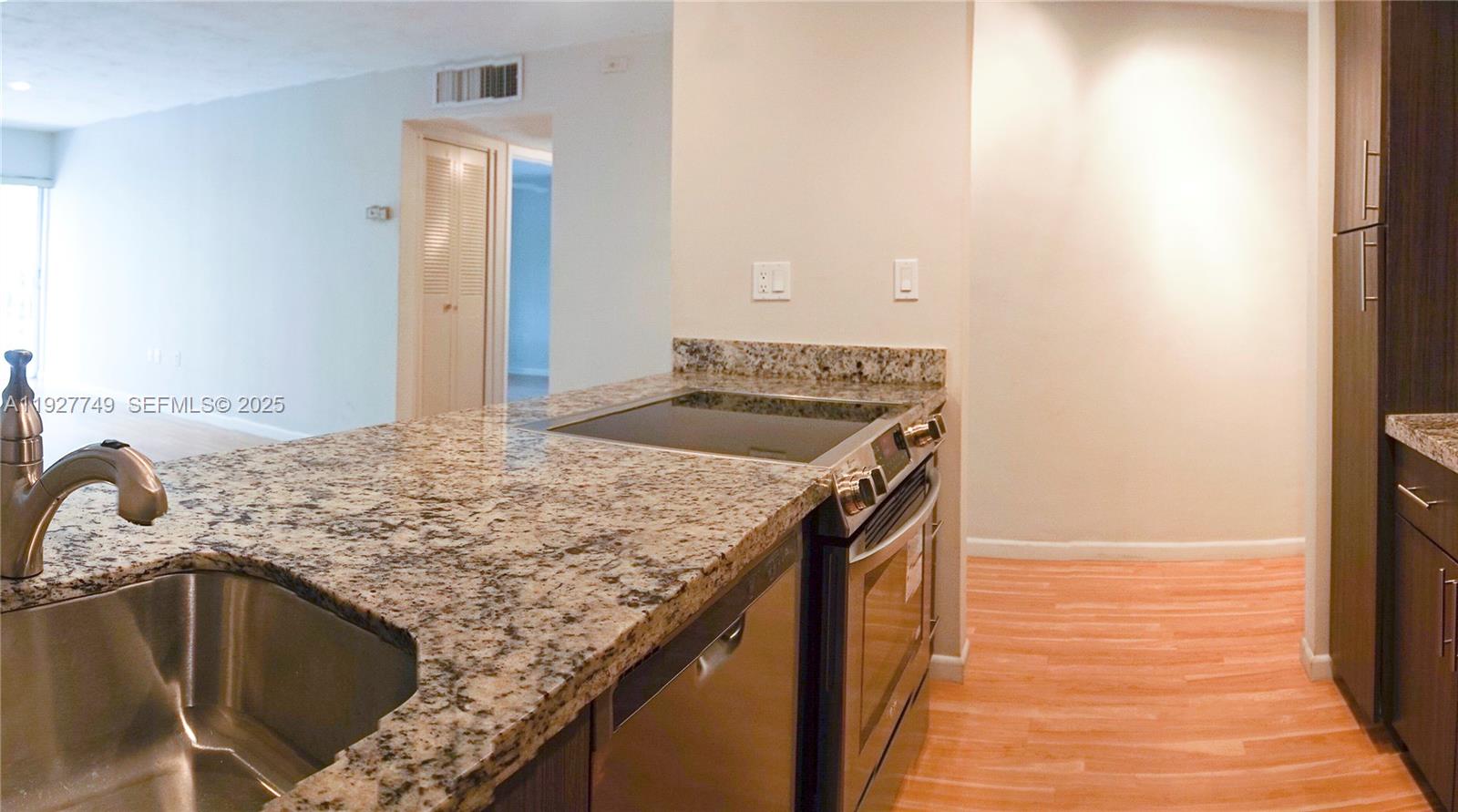9651 Southwest 77th Avenue, Unit 304E Miami, FL 33156 - Photo 11 of 19 a kitchen with a sink and a refrigerator