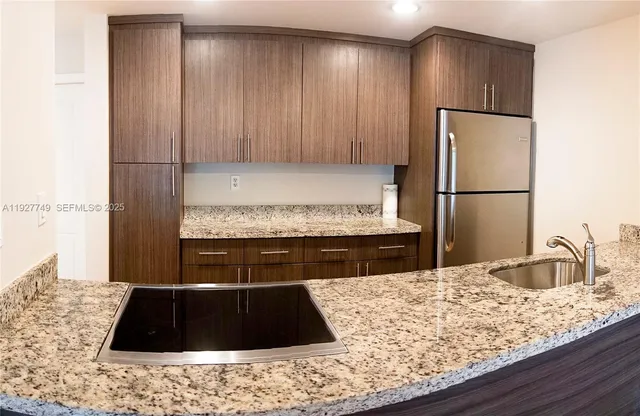 a bathroom with a granite countertop sink a toilet and shower
