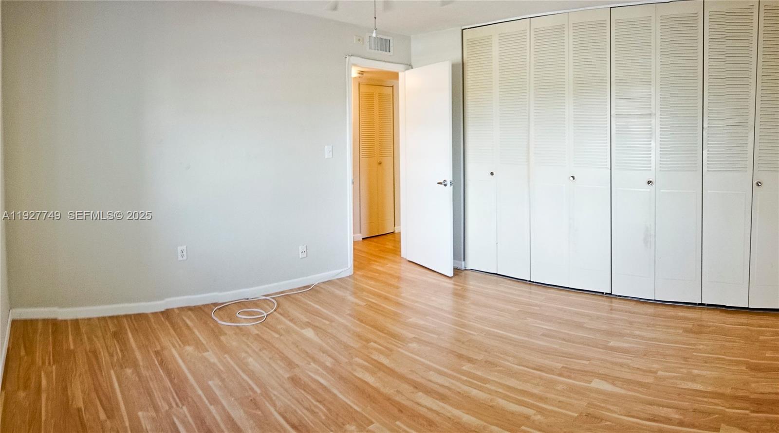 9651 Southwest 77th Avenue, Unit 304E Miami, FL 33156 - Photo 15 of 19 a view of an empty room with wooden floor