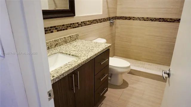 a bathroom with a granite countertop sink and mirror