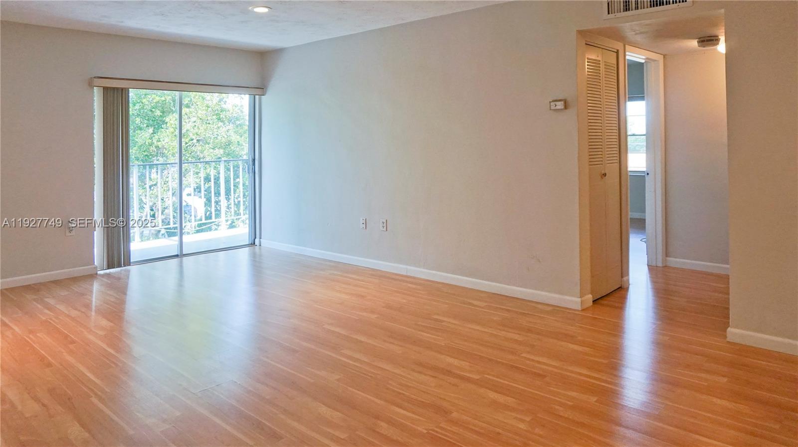 9651 Southwest 77th Avenue, Unit 304E Miami, FL 33156 - Photo 19 of 19 a view of an empty room with wooden floor and a window