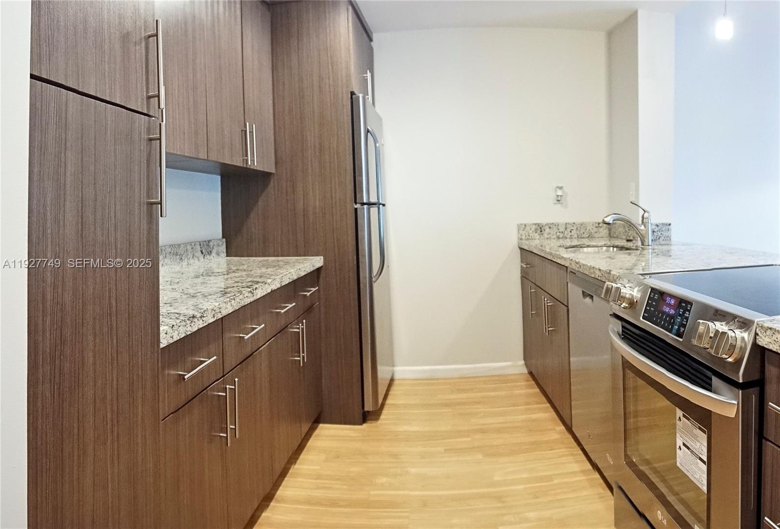 9651 Southwest 77th Avenue, Unit 304E Miami, FL 33156 - Photo 10 of 19 a kitchen with a sink stove and refrigerator