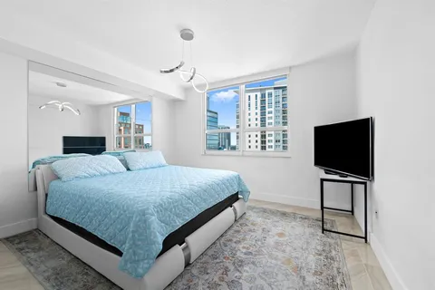 a bedroom with a bed and a flat screen television