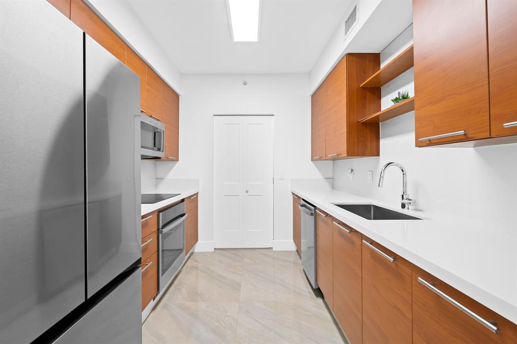 350 Southeast 2nd Street, Unit 2280 Fort Lauderdale, FL 33301 - Photo 9 of 25 a kitchen with stainless steel appliances granite countertop a sink and a stove
