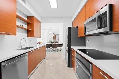 a kitchen with stainless steel appliances granite countertop a sink and a stove