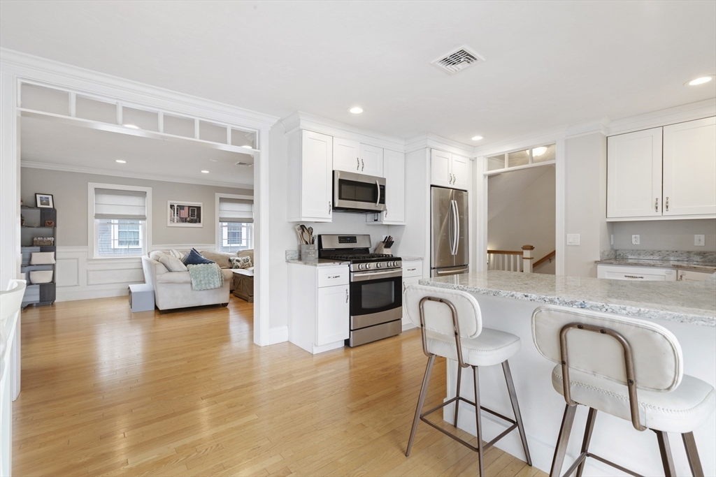 113 Elm Street, Unit D Quincy, MA 02169 - Photo 10 of 39 a kitchen with granite countertop lots of white cabinets and stainless steel appliances