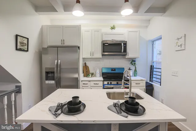 a kitchen with stainless steel appliances a sink a stove and a refrigerator
