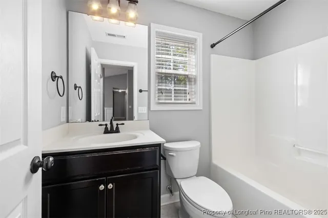 a bathroom with a sink vanity mirror and toilet