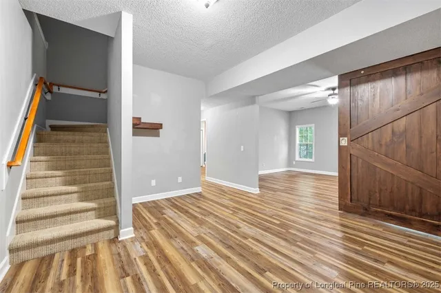a view of a room with wooden floor and stairs
