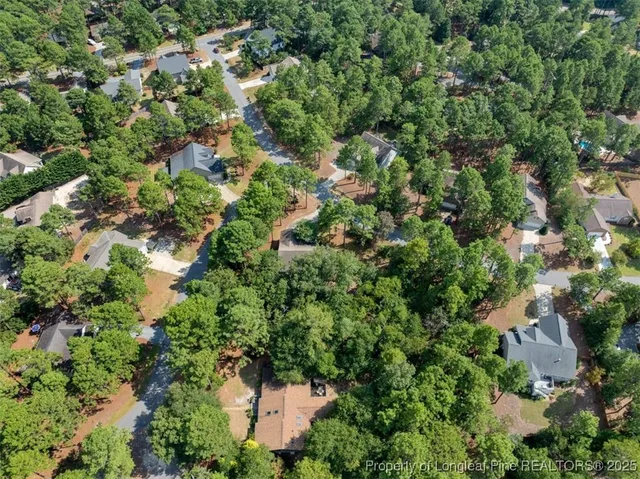 an aerial view of residential house with outdoor space and trees all around