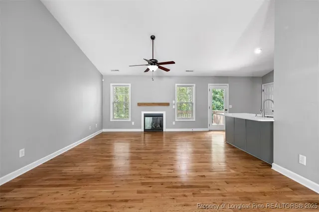 a view of an empty room with a fireplace and a window