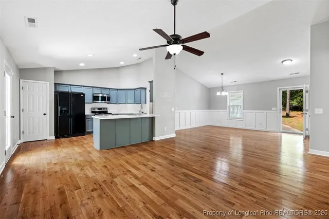 a view of kitchen with refrigerator stove and wooden floor