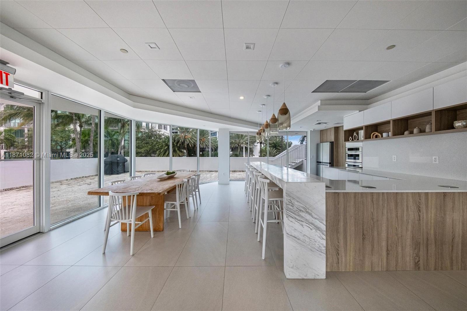 5900 Collins Avenue, Unit 1905 Miami Beach, FL 33140 - Photo 21 of 22 a dining hall with stainless steel appliances kitchen island granite countertop a table and chairs
