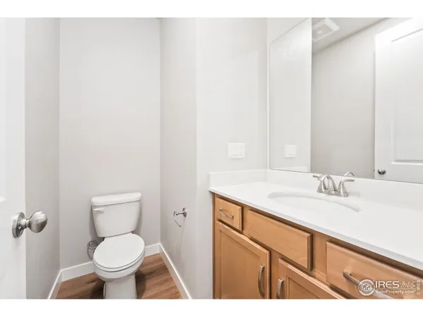 a bathroom with a granite countertop toilet sink and mirror