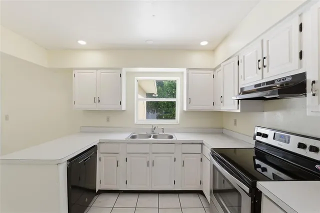 a kitchen with cabinets appliances a sink and a window