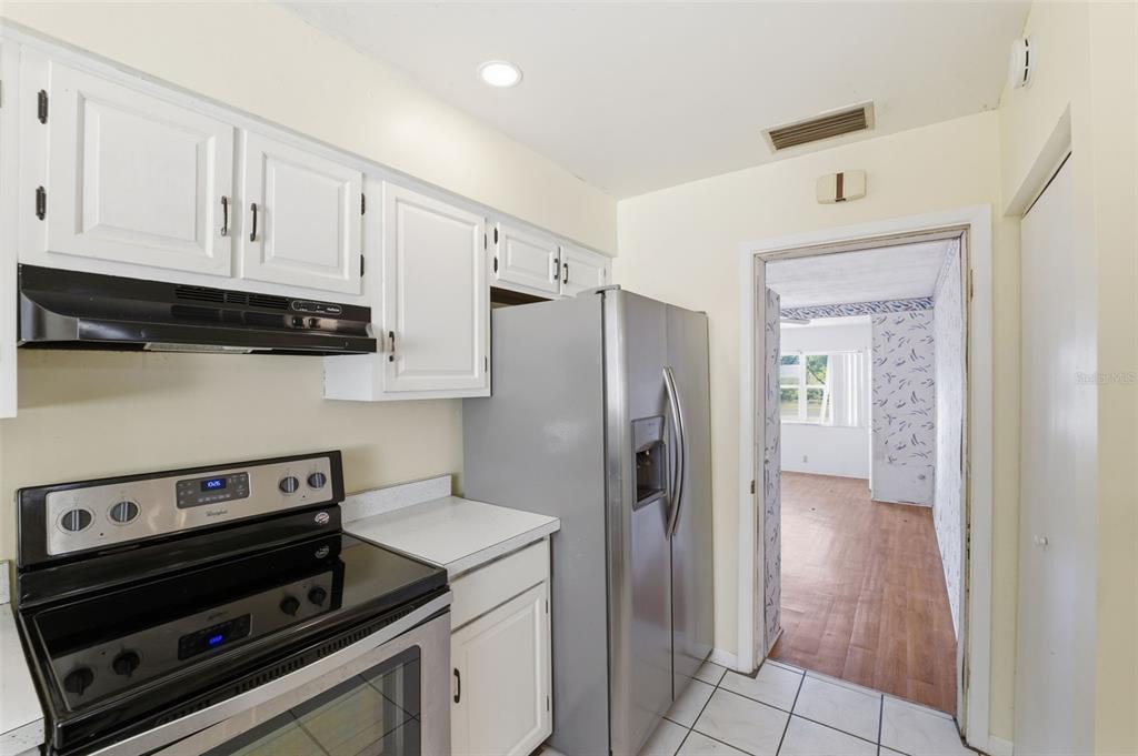 6229 Dalton Street Spring Hill, FL 34606 - Photo 13 of 44 a kitchen with a refrigerator stove and cabinets