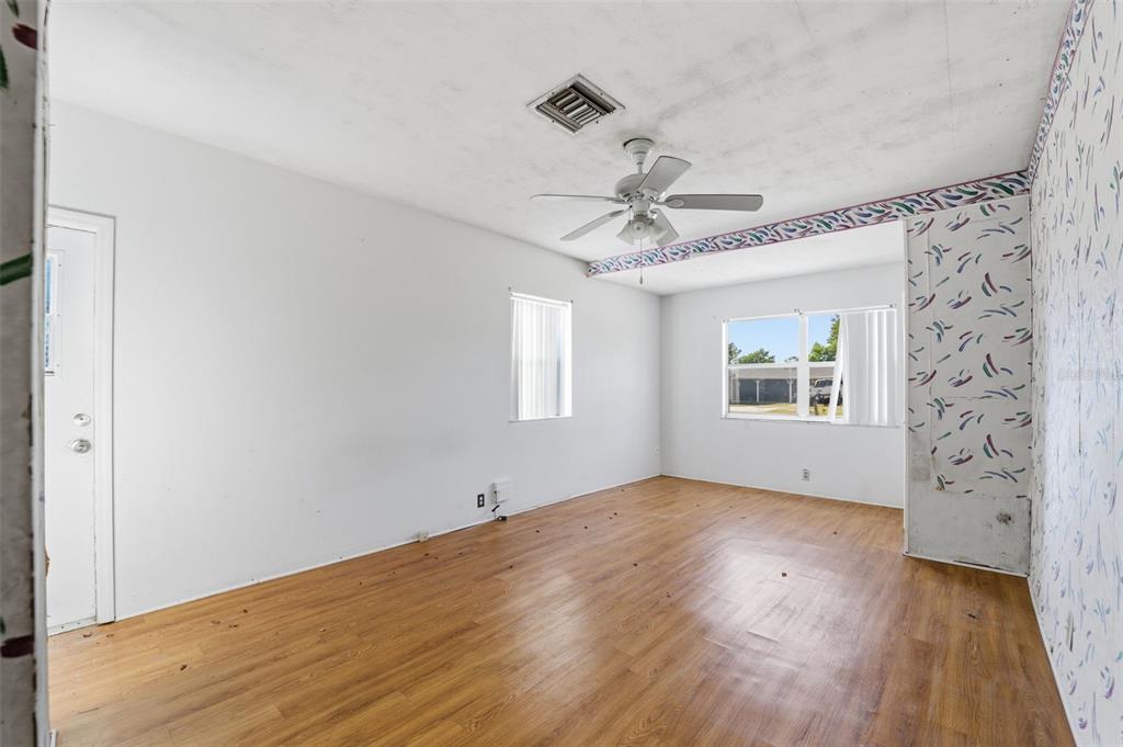 6229 Dalton Street Spring Hill, FL 34606 - Photo 14 of 44 an empty room with wooden floor chandelier fan and windows