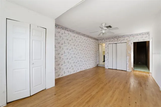 a view of an empty room with wooden floor