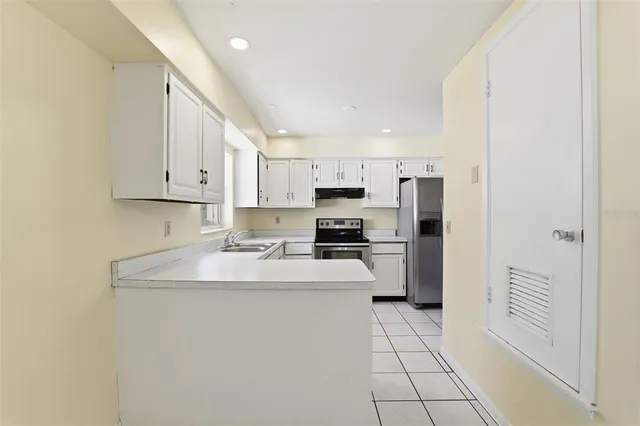 a kitchen with a sink a refrigerator and cabinets