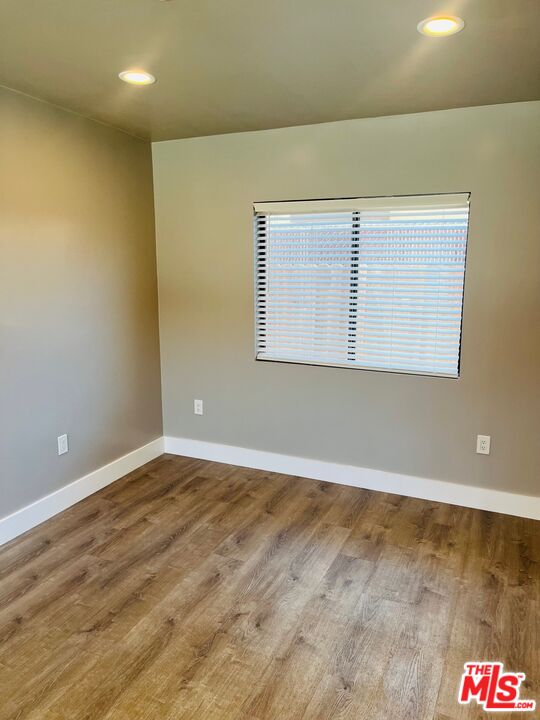 2807 Buckingham Road, Unit 1/2 Los Angeles, CA 90016 - Photo 3 of 10 an empty room with wooden floor and windows