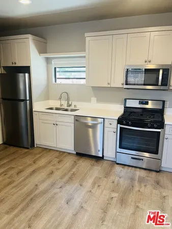 a kitchen with stainless steel appliances a stove a microwave and a sink