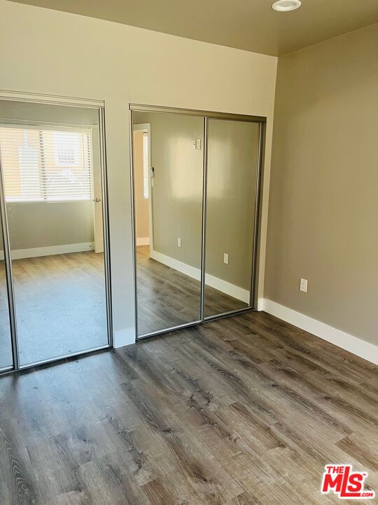 2807 Buckingham Road, Unit 1/2 Los Angeles, CA 90016 - Photo 7 of 10 an empty room with wooden floor and door
