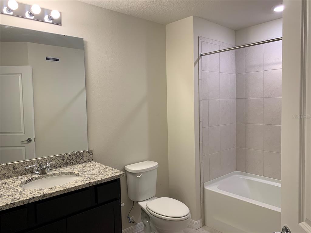 2559 Buena View Road Kissimmee, FL 34746 - Photo 13 of 17 a bathroom with a granite countertop sink toilet and shower