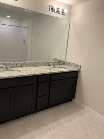 a bathroom with a granite countertop sink and a mirror